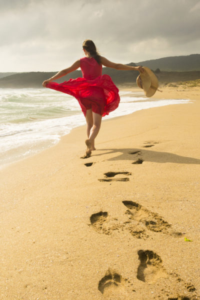Beautiful happy woman running freely on the beach